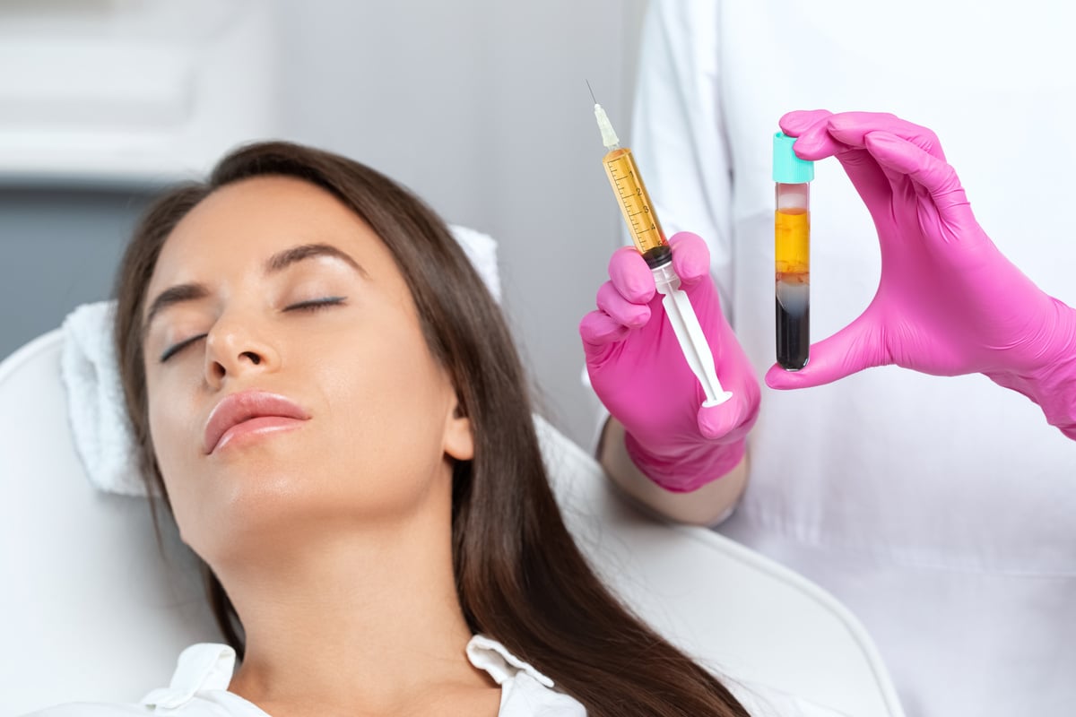 Beautician will do PRP therapy for the face against wrinkles. She has blood plasma for injections and a syringe with plasma in her test tube. Cosmetology in the beauty salon.